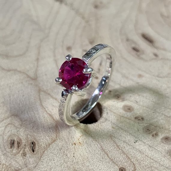 Sterling silver band with a prong set red quartz stone